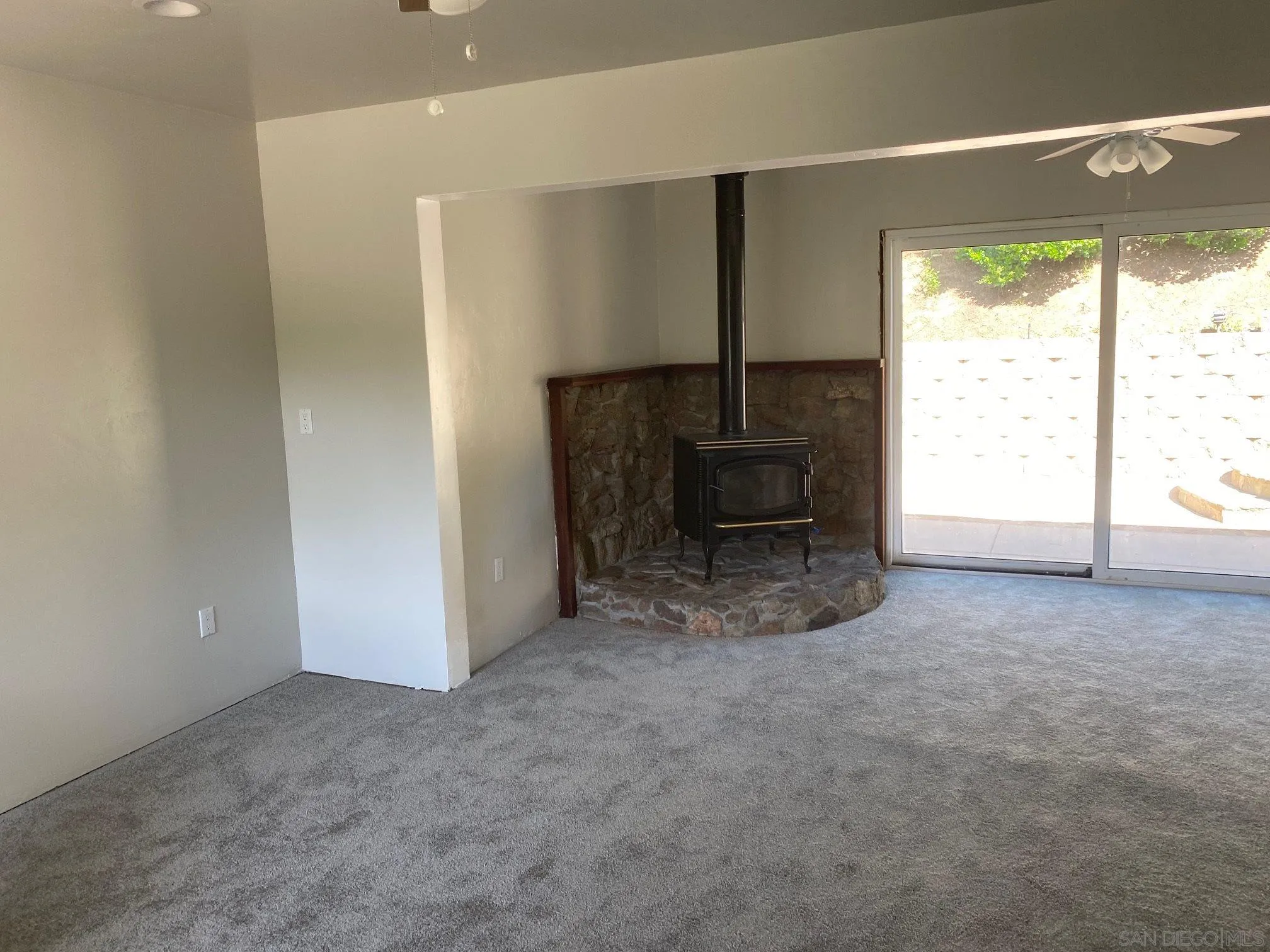 9243 Westhill Road Lakeside, CA 92040 - Photo 18 of 26 an empty room with a fireplace and a window
