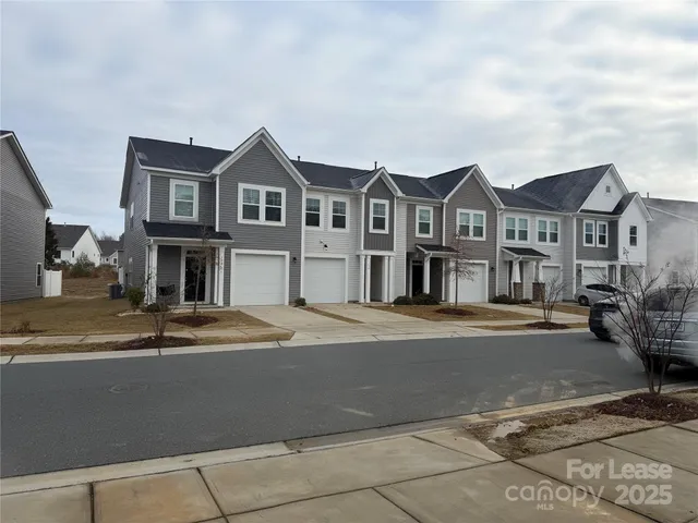 a front view of a house with yard and parking
