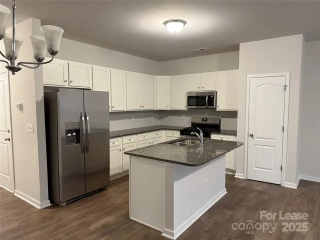 a kitchen with a stove a refrigerator and a sink