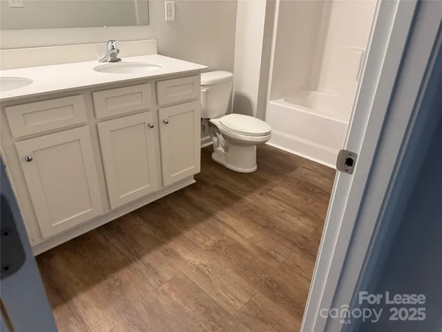 a spacious bathroom with a sink a toilet and a mirror