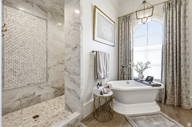 71 Farm Road Midway, UT 84049 - Photo 38 of 92 Freestanding pedestal bathtub with a large arched window, complemented by a spacious walk-in shower featuring patterned tile inlay, full-height tile walls, and hexagon tile flooring