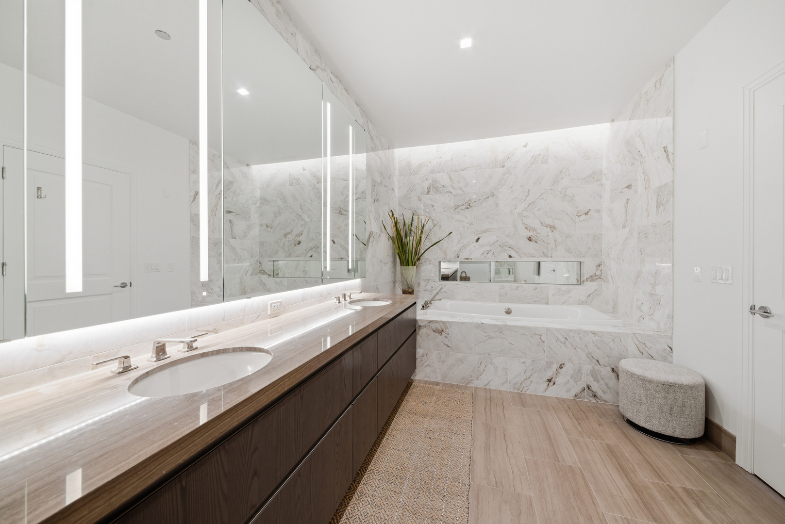 363 East Wacker Drive, Unit 2708 Chicago, IL 60601 - Photo 14 of 48 a bathroom with a granite countertop bathtub a sink and a large mirror