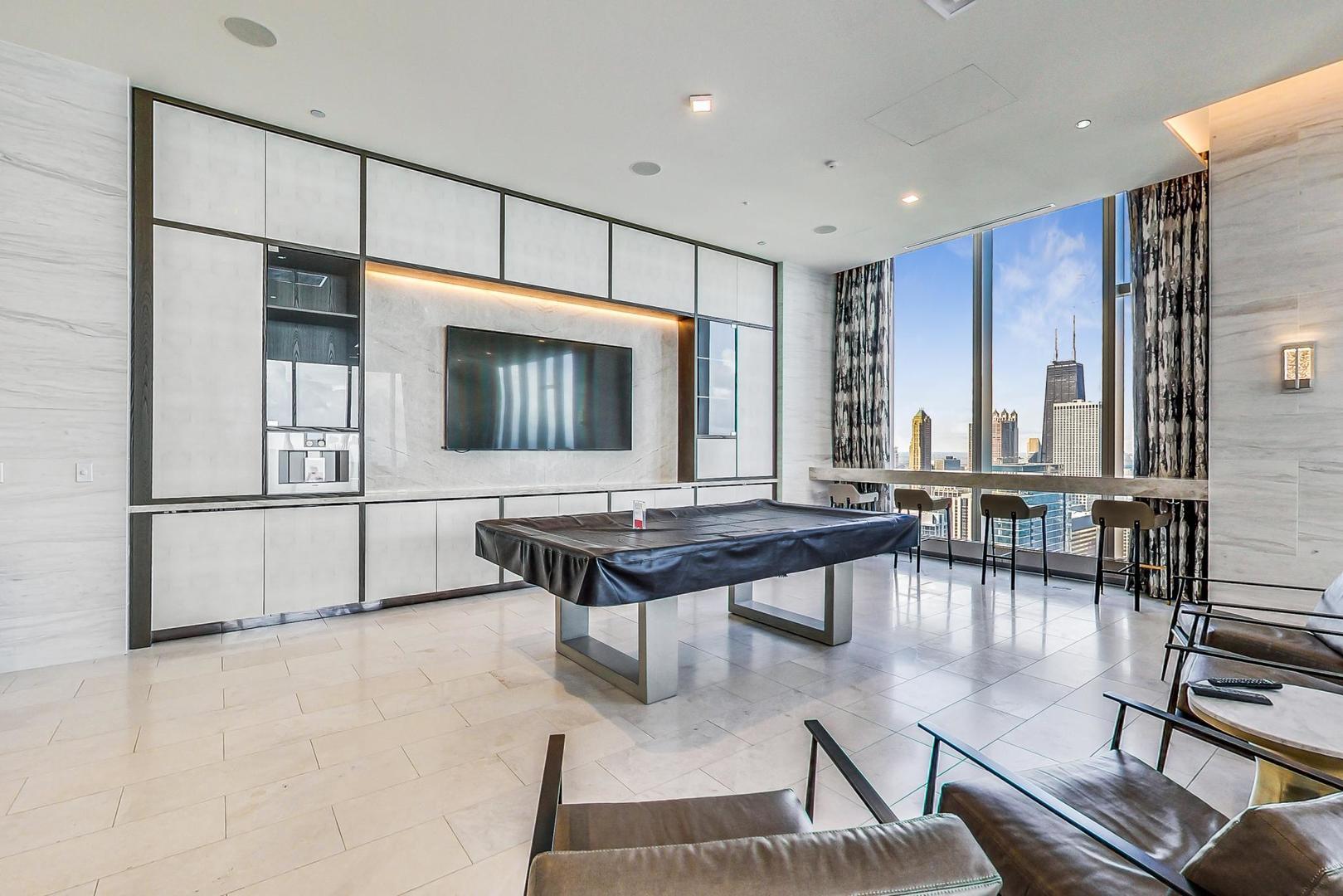 363 East Wacker Drive, Unit 2708 Chicago, IL 60601 - Photo 24 of 48 a living room with furniture a flat screen tv and kitchen view