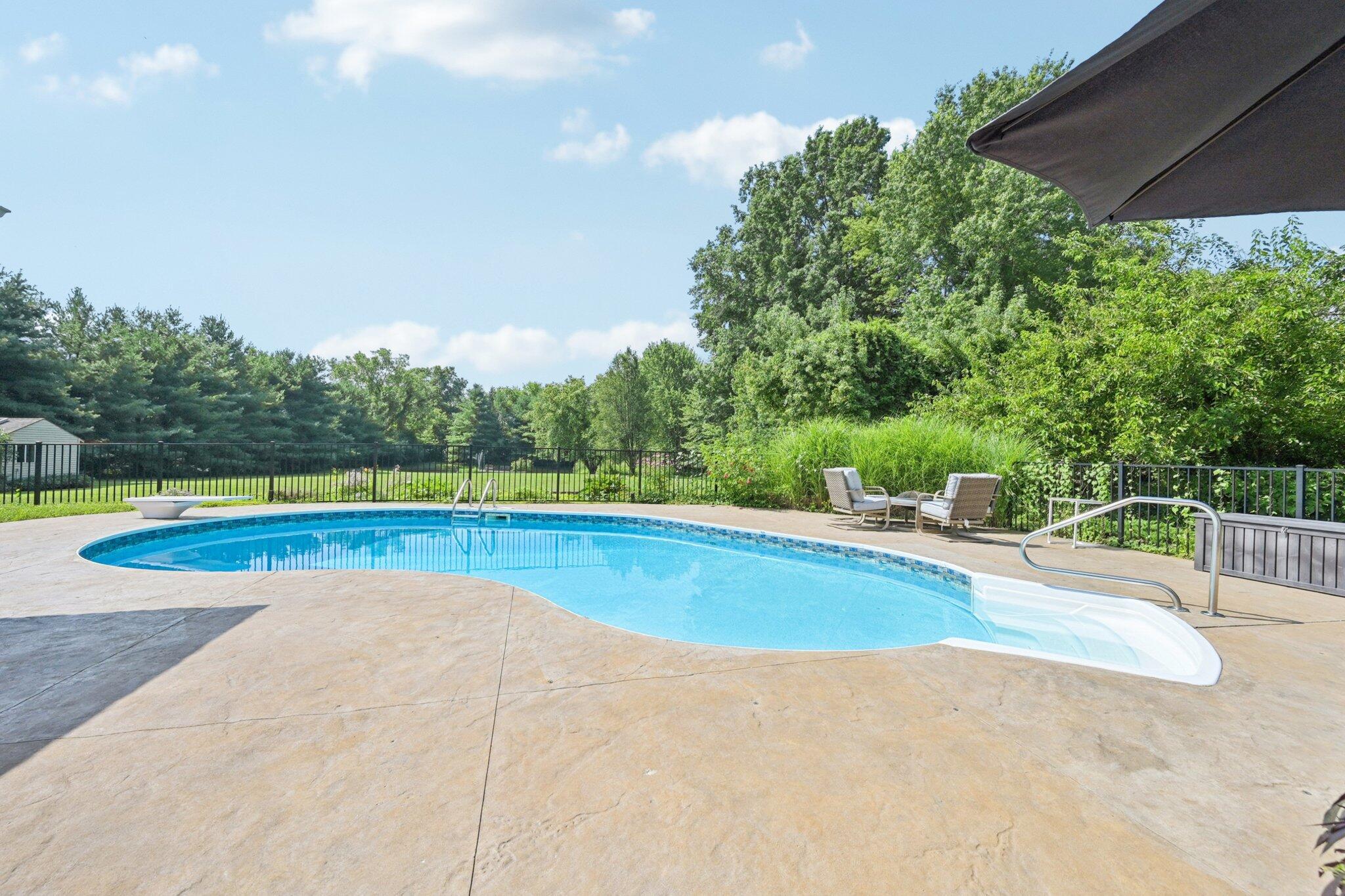 7700 Plumb Road Galena, OH 43021 - Photo 11 of 94 Enjoy peaceful mornings or lively afternoons beside this stunning in-ground pool surrounded by lush landscaping and a private tree-lined backdrop.