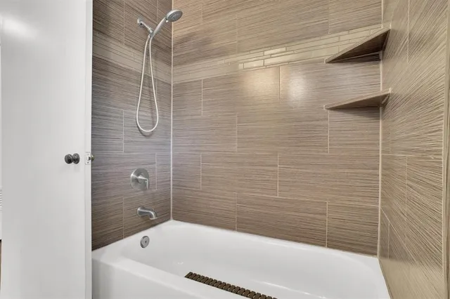 a bathroom with a bathtub and shower