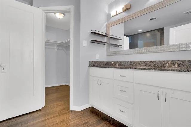 a hallway with cabinets and wooden floor