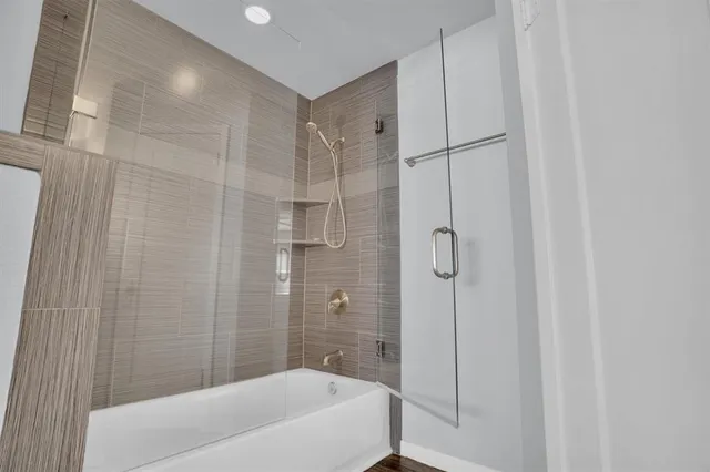 a bathroom with a shower and a bath tub