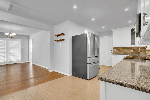 a kitchen with granite countertop a refrigerator and a sink