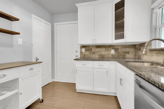 a kitchen with granite countertop white cabinets and white appliances