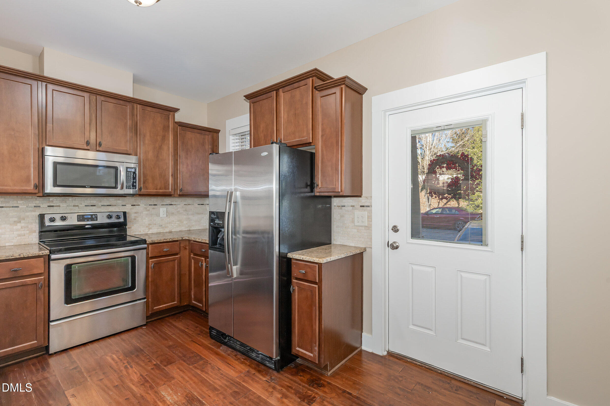 3827 Glenhaven Road Raleigh, NC 27606 - Photo 13 of 32 a kitchen with granite countertop a refrigerator stove and microwave