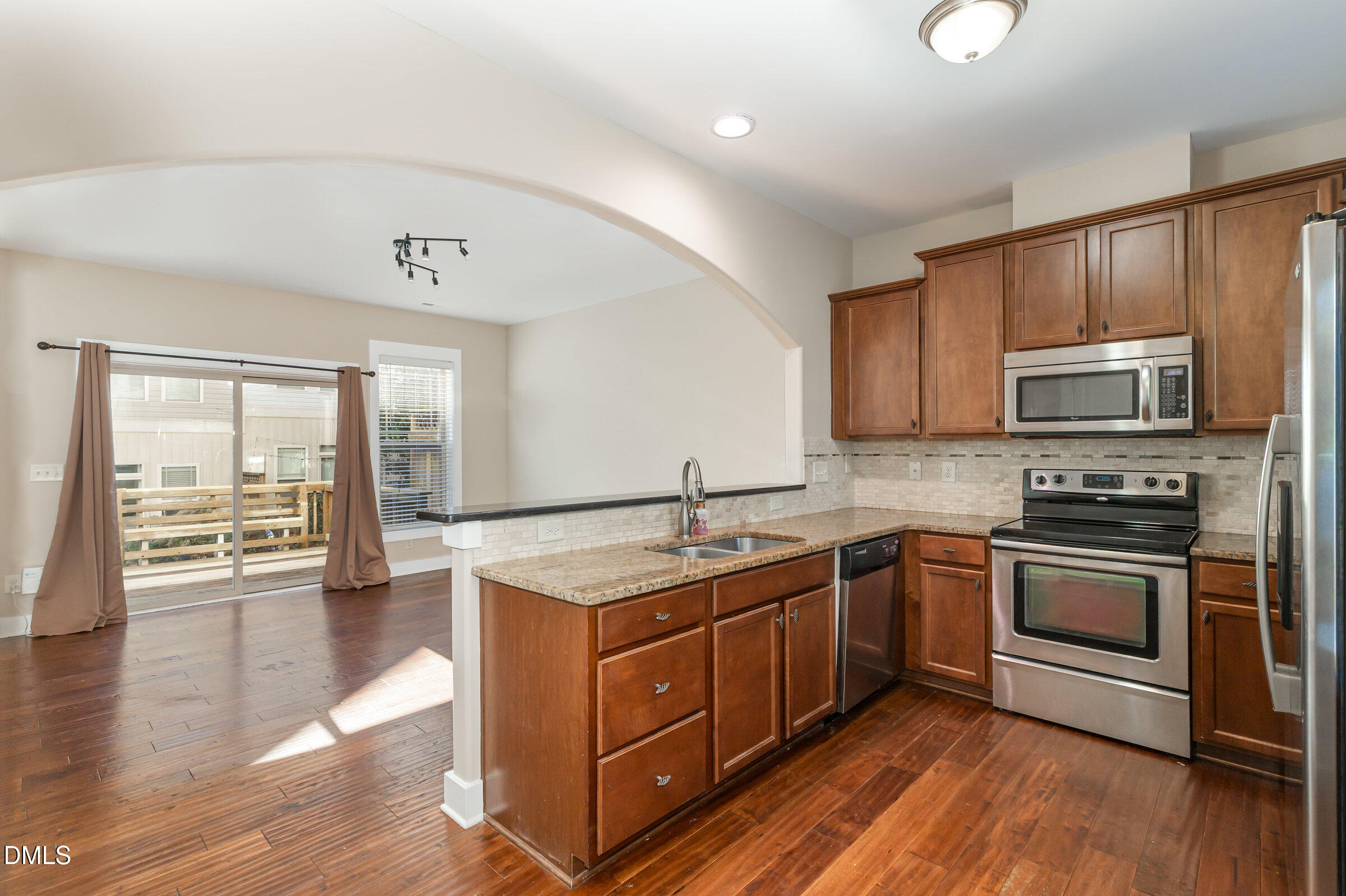 3827 Glenhaven Road Raleigh, NC 27606 - Photo 14 of 32 a kitchen with stainless steel appliances granite countertop wooden cabinets a stove a sink and dishwasher with wooden floor