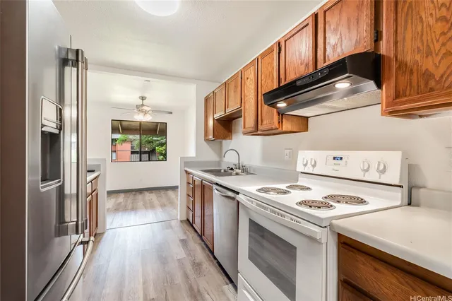 a kitchen with stainless steel appliances granite countertop a stove a refrigerator and a cabinets