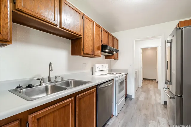 a kitchen with stainless steel appliances granite countertop a sink stove and refrigerator