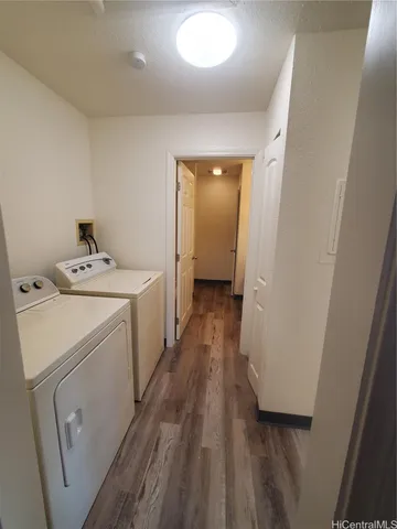 a storage room with wooden floor washer and dryer