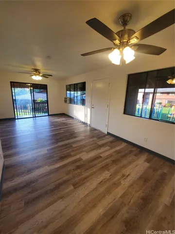 a view of a livingroom with wooden floor and a ceiling fan