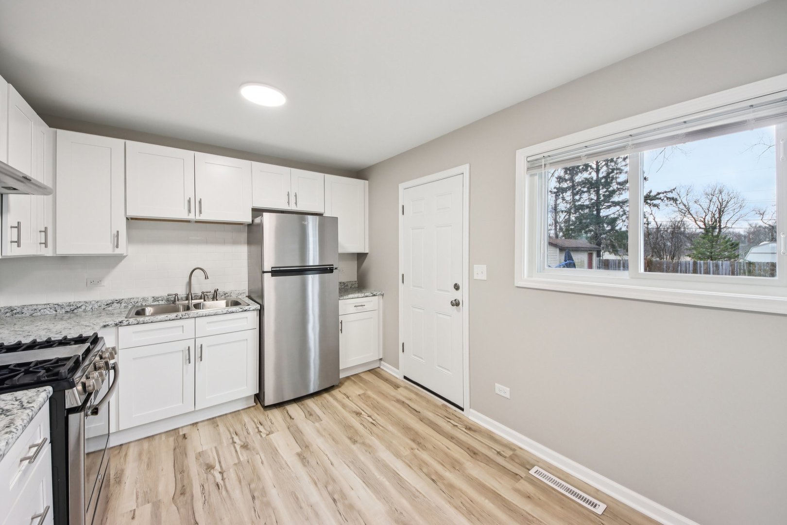 65 Della Street Crystal Lake, IL 60014 - Photo 11 of 28 a kitchen with granite countertop white cabinets and white appliances