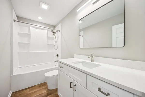 a bathroom with a sink a toilet and shower