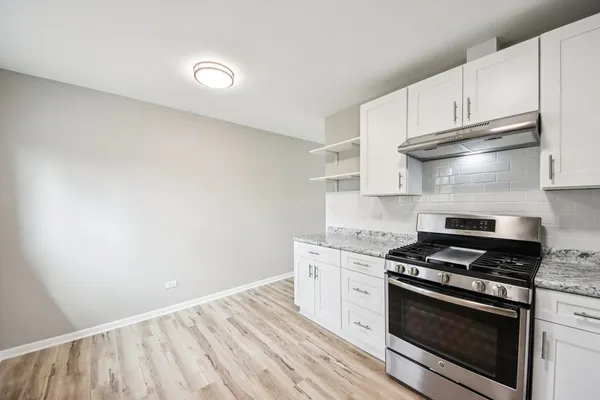 a kitchen with granite countertop a stove and a sink
