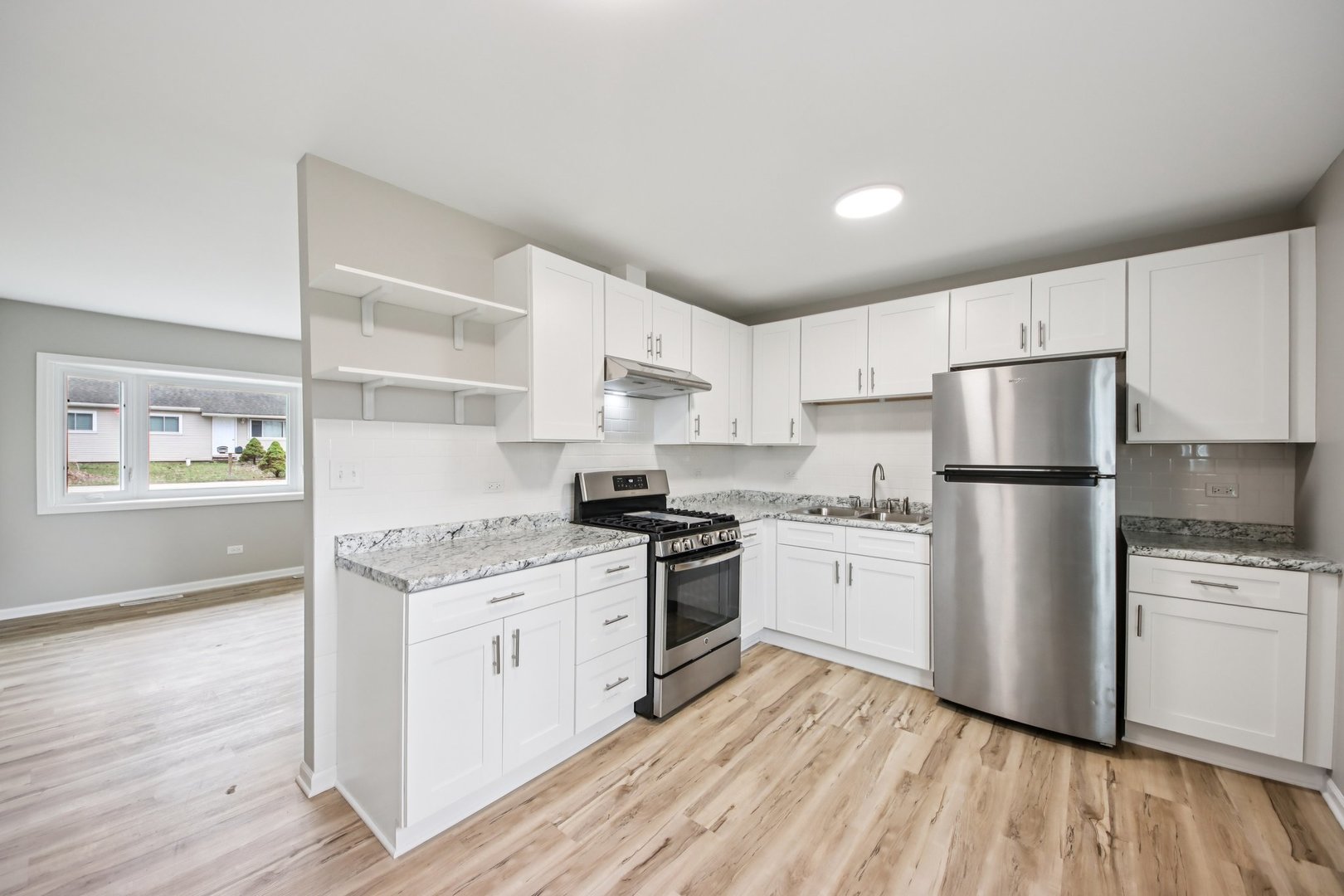 65 Della Street Crystal Lake, IL 60014 - Photo 10 of 28 a kitchen with a white cabinets and wooden floor