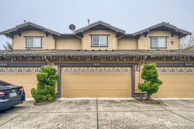 a view of a house with a yard and potted plants