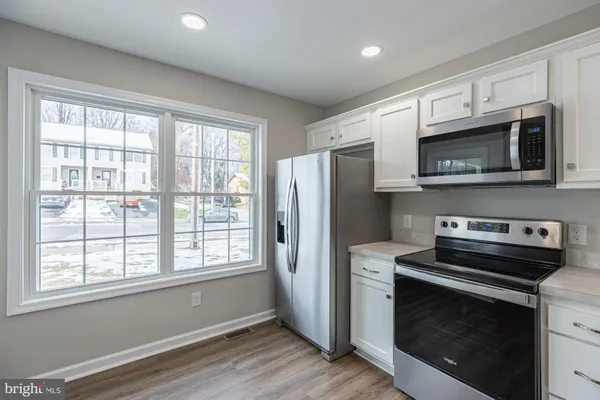 a kitchen with stainless steel appliances a stove a microwave and a window