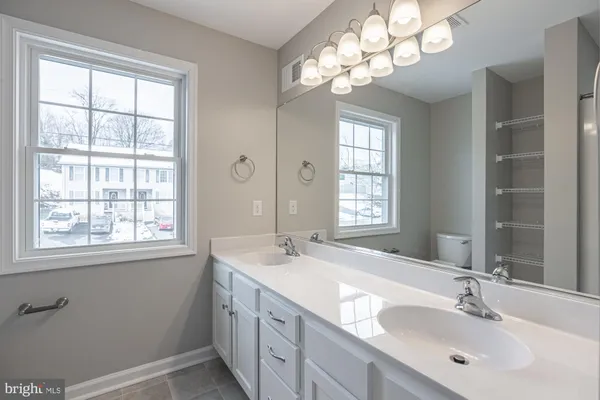 a bathroom with double vanity and a mirror