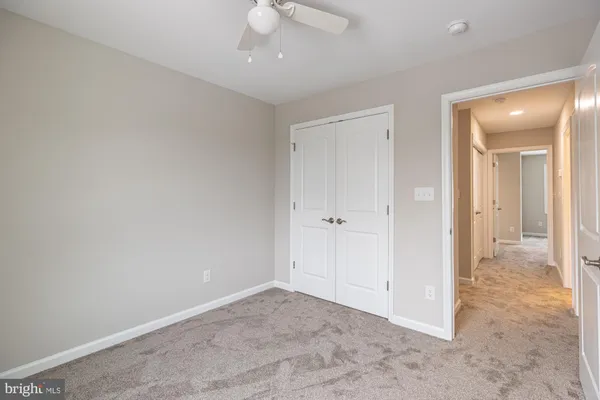 an empty room with fan and entrance
