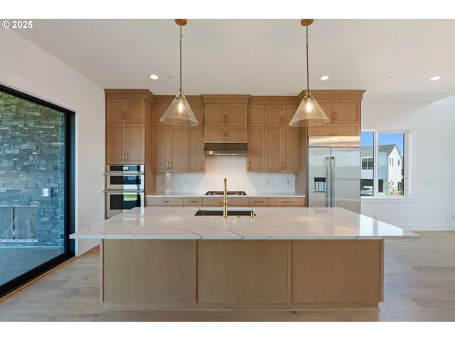 a kitchen with kitchen island a counter space a sink appliances and cabinets