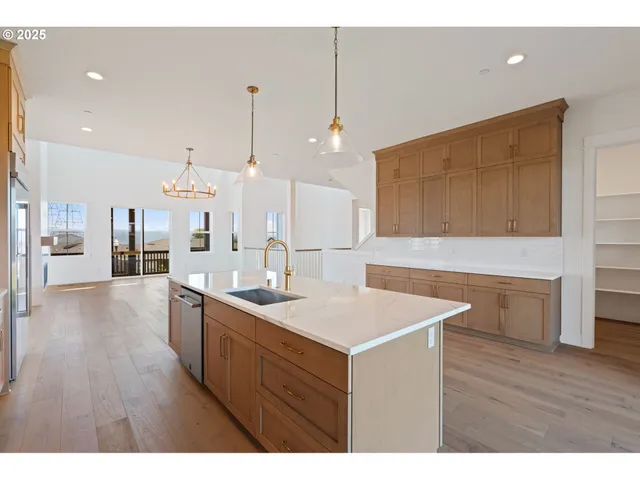 a view of kitchen island a sink wooden floor and living room view