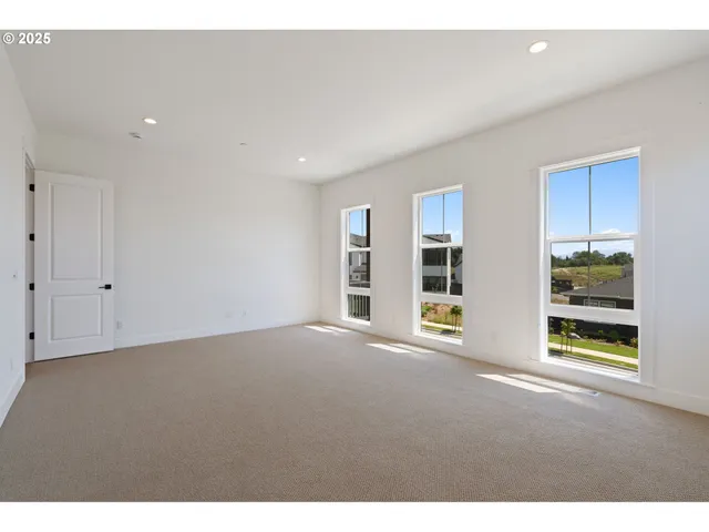 a view of an empty room with window and cabinet