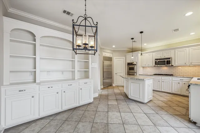a kitchen with white cabinets and appliances