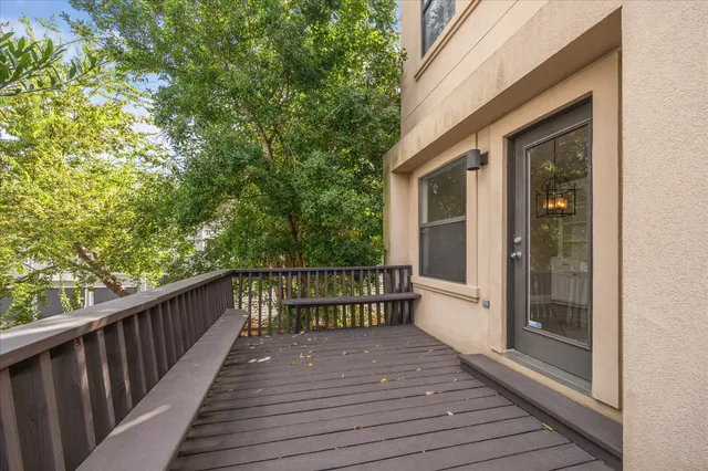 a view of a balcony with wooden floor and iron fence