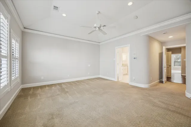 an empty room with fan and windows
