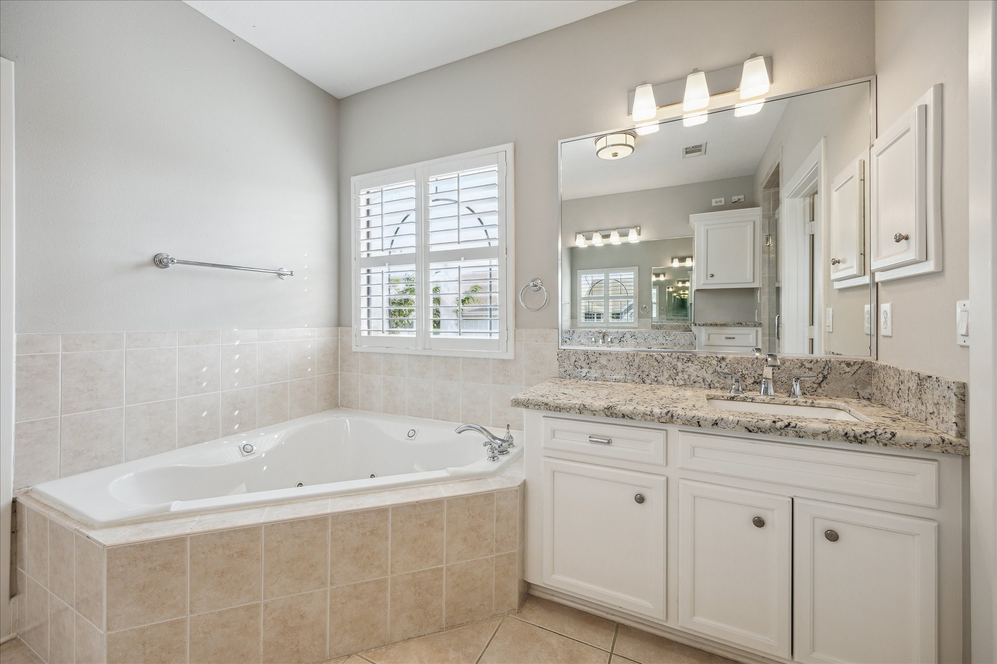 2817 Newman Street Houston, TX 77098 - Photo 26 of 36 a bathroom with a granite countertop tub sink and mirror