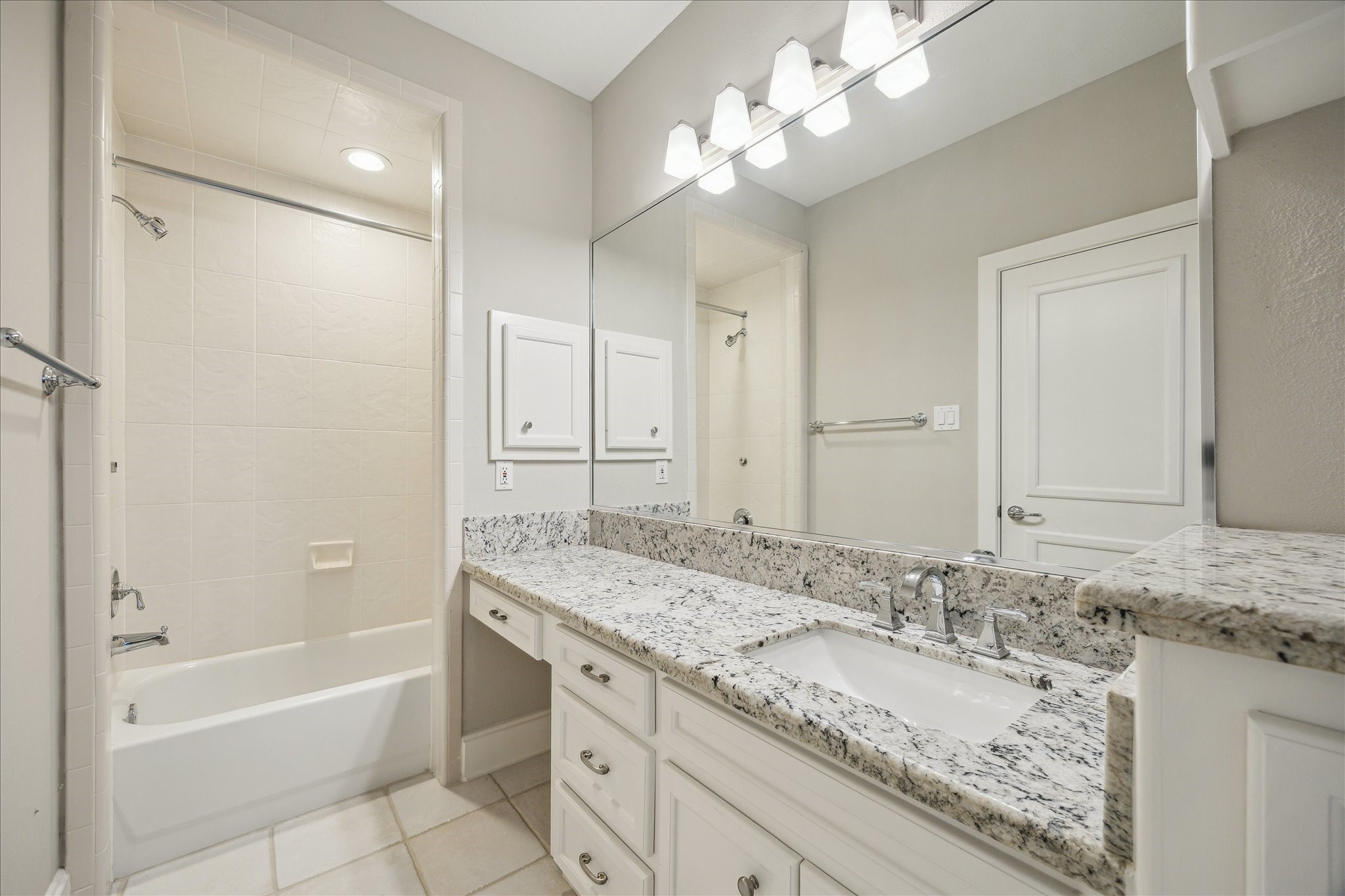 2817 Newman Street Houston, TX 77098 - Photo 8 of 36 a bathroom with a granite countertop double vanity sink and mirror with bathtub
