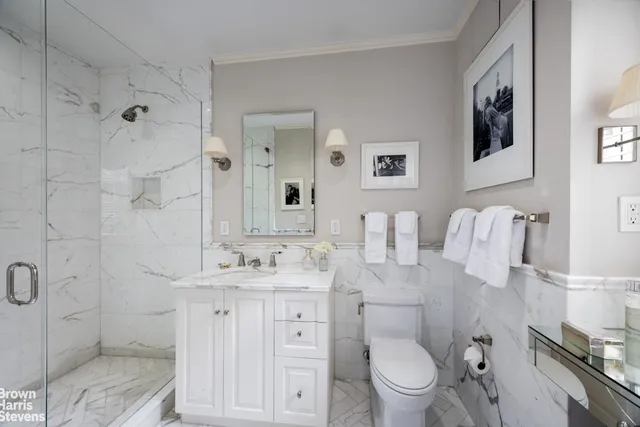 a bathroom with a sink toilet vanity and shower