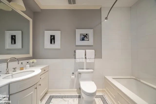 a bathroom with a granite countertop toilet sink and mirror