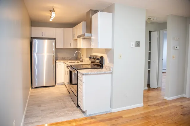 a kitchen with a refrigerator sink and cabinets