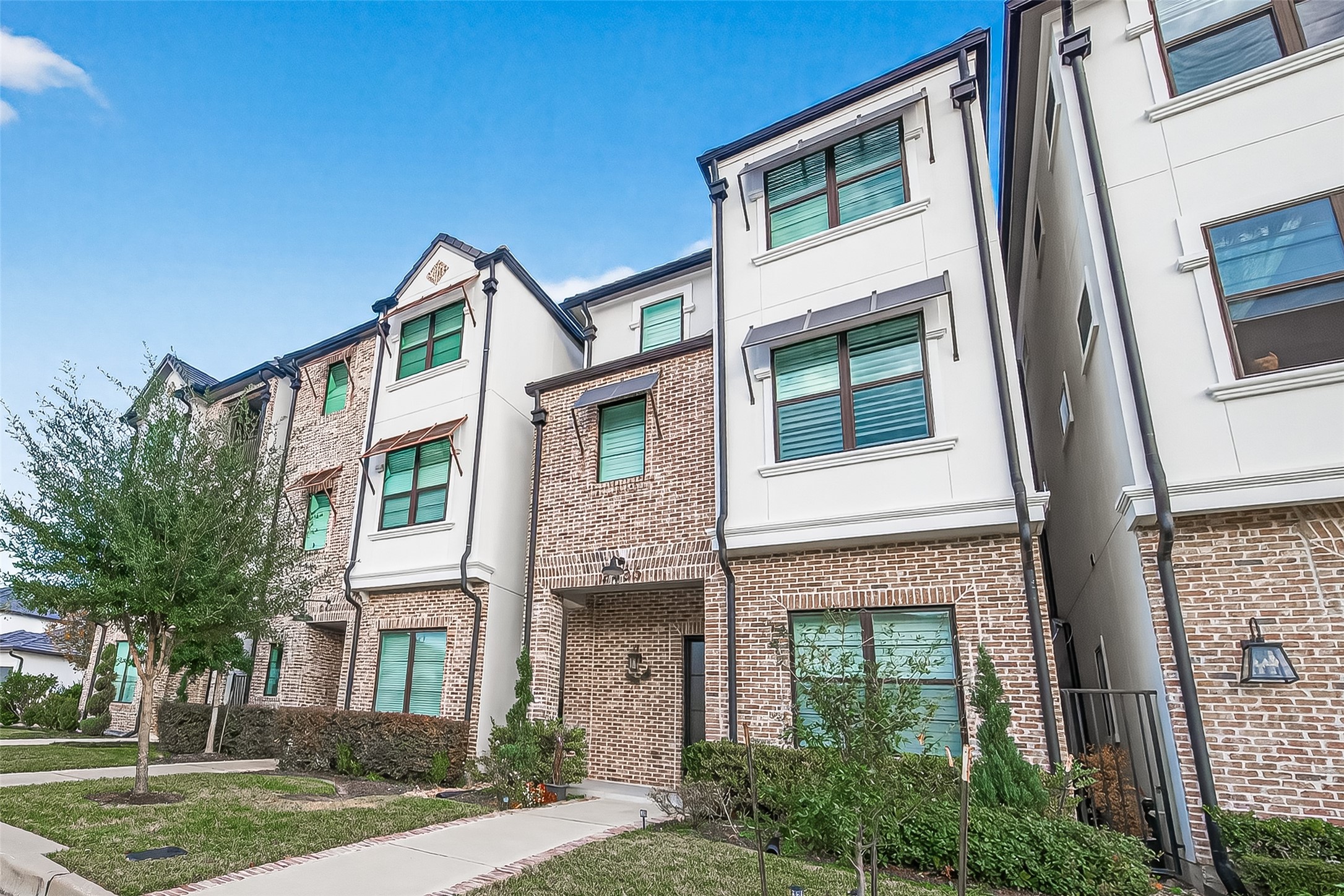 2435 Prairie Hollow Lane Houston, TX 77077 - Photo 2 of 50 a view of a brick house with many windows next to a yard