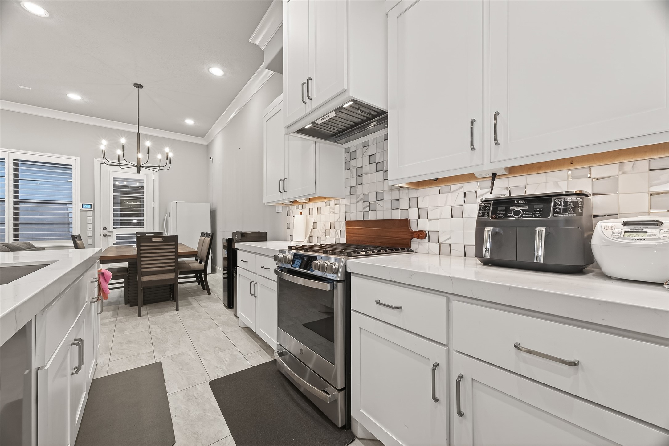 2435 Prairie Hollow Lane Houston, TX 77077 - Photo 22 of 50 a kitchen with a sink dishwasher a stove and white cabinets with wooden floor