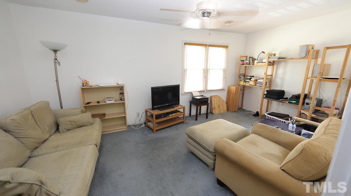 2947 Wycliff Road Raleigh, NC 27607 - Photo 6 of 11 a living room with furniture a flat screen tv and a window