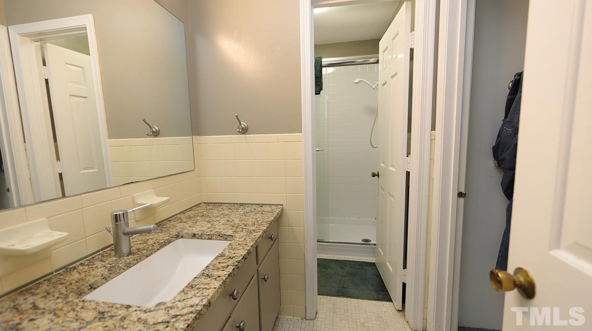 2947 Wycliff Road Raleigh, NC 27607 - Photo 8 of 11 a bathroom with a granite countertop sink and a mirror