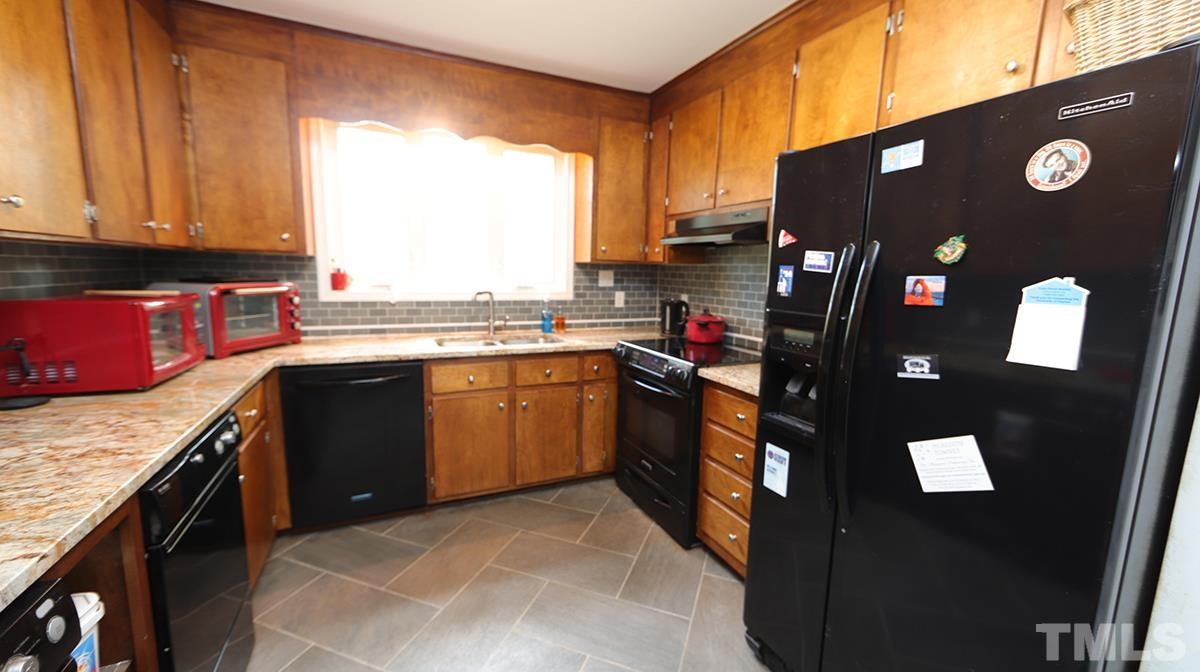 2947 Wycliff Road Raleigh, NC 27607 - Photo 9 of 11 a kitchen with stainless steel appliances granite countertop a sink stove and refrigerator