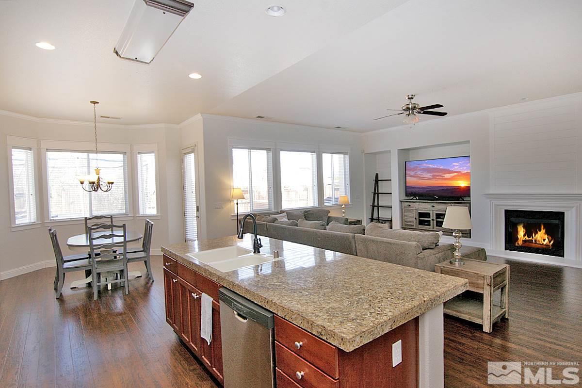 1695 Silver Thread Drive Reno, NV 89521 - Photo 4 of 15 an open kitchen with granite countertop a table and chairs in it