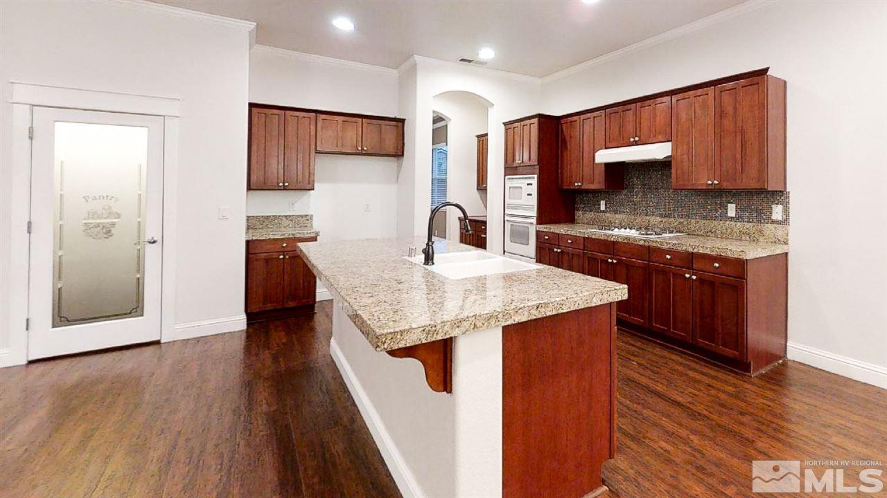 1695 Silver Thread Drive Reno, NV 89521 - Photo 8 of 15 a kitchen with stainless steel appliances granite countertop a sink stove and refrigerator
