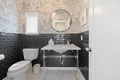 a bathroom with a sink toilet and mirror