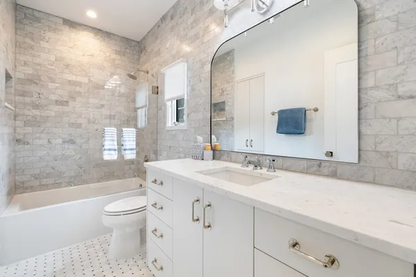 a bathroom with a sink a toilet tub and shower