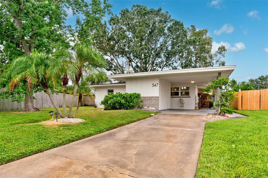a front view of a house with a yard and potted plants