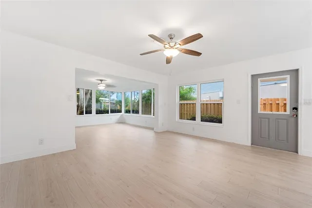 a view of n empty room with wooden floor and fan