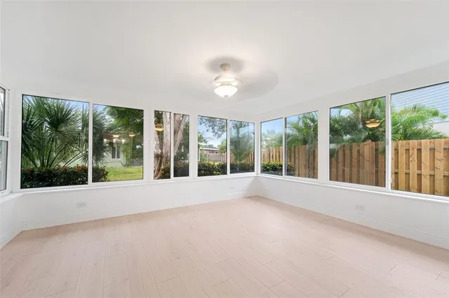 a view of an empty room with wooden floor and a floor to ceiling window